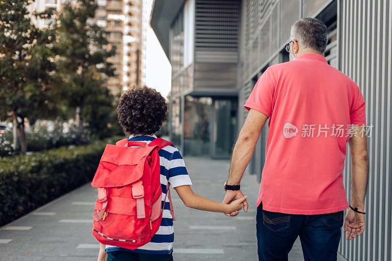 Boy and his father walking to school